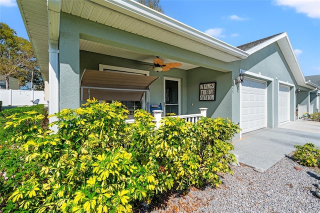 6745 Basswood Cir, Zephyrhills, FL 33542 - view of front of property featuring ceiling fan, a garage, stucco siding, fence, and concrete driveway