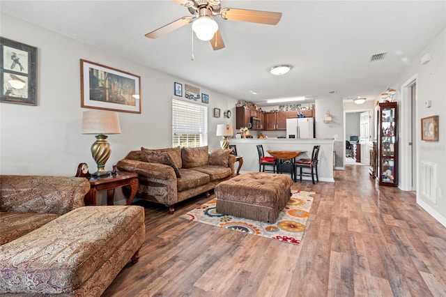 6745 Basswood Cir, Zephyrhills, FL 33542 - living area featuring visible vents, ceiling fan, and wood finished floors