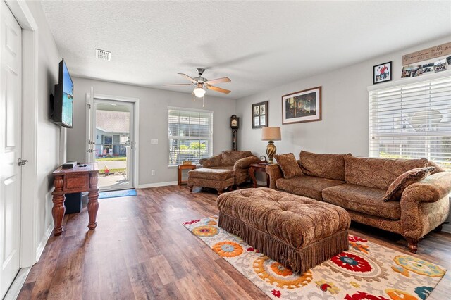 6745 Basswood Cir, Zephyrhills, FL 33542 - living room with baseboards, a textured ceiling, visible vents, ceiling fan, and wood finished floors