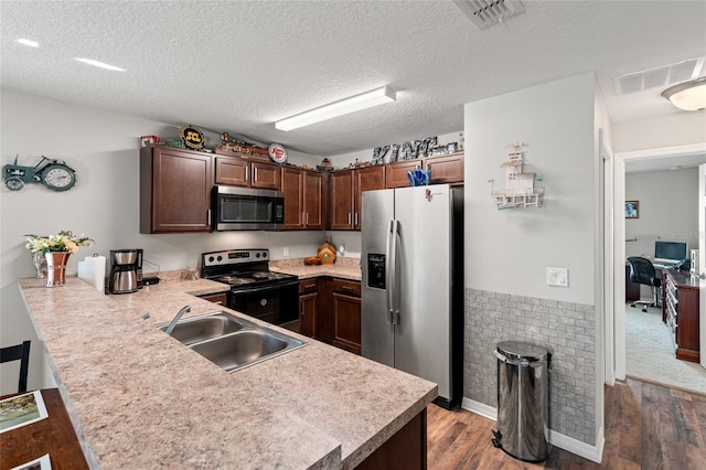 6745 Basswood Cir, Zephyrhills, FL 33542 - kitchen with visible vents, a sink, appliances with stainless steel finishes, a peninsula, and wood finished floors