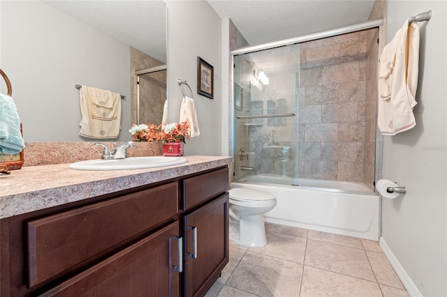 6745 Basswood Cir, Zephyrhills, FL 33542 - full bathroom featuring a textured ceiling, vanity, tile patterned flooring, toilet, and combined bath / shower with glass door