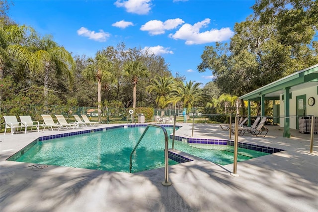 4769 Stoneview Cir, Oldsmar, FL 34677 - community pool with an in-ground hot tub, a patio area, fence, cooling unit, and view of wooded area