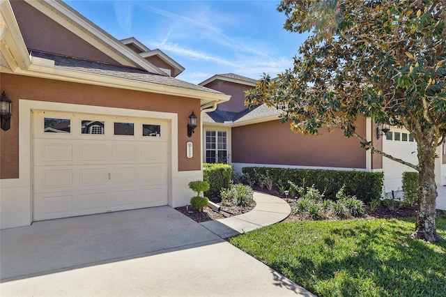 view of front of home with concrete driveway, stucco siding, and a garage