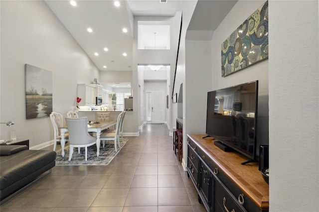 living room featuring tile patterned floors, high vaulted ceiling, baseboards, and recessed lighting