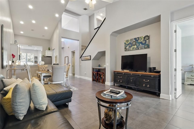 tiled living room featuring visible vents, baseboards, a high ceiling, a ceiling fan, and recessed lighting