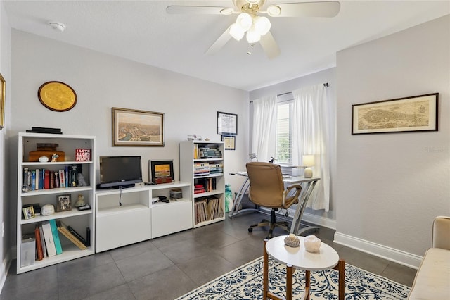 office space with baseboards, a ceiling fan, and dark tile patterned flooring