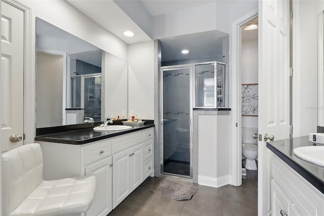 bathroom with toilet, a shower stall, recessed lighting, vanity, and tile patterned floors