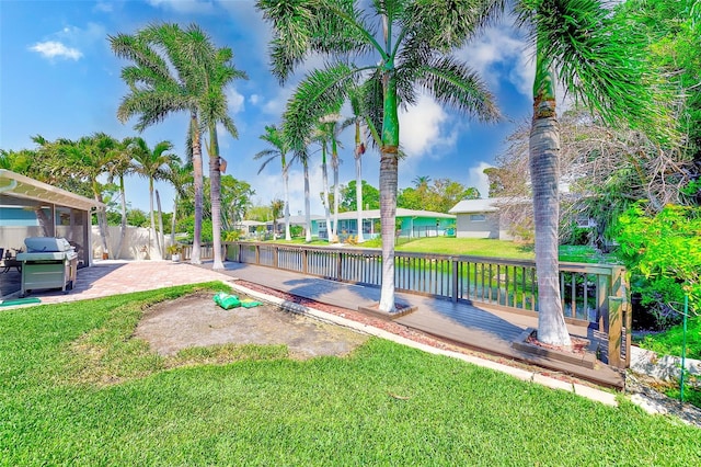 view of property's community with a water view, a yard, a patio, and fence