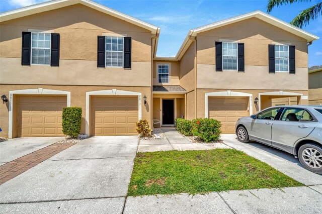 8013 Savannah Sunset Ln, Tampa, FL 33615 - multi unit property featuring driveway, stucco siding, and a garage