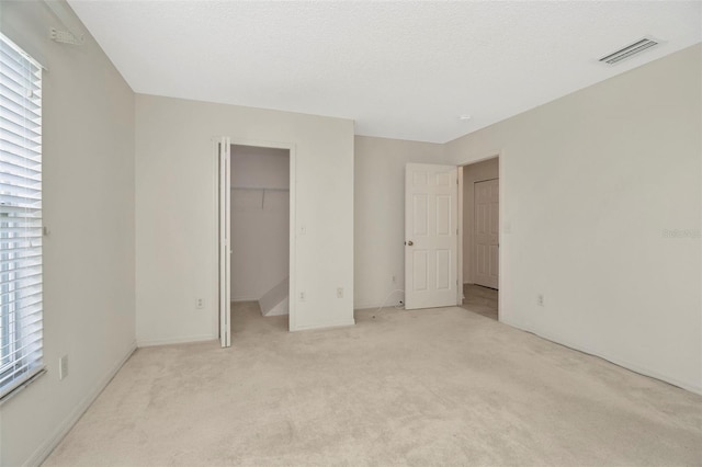 8013 Savannah Sunset Ln, Tampa, FL 33615 - unfurnished bedroom featuring light colored carpet, visible vents, baseboards, and a spacious closet