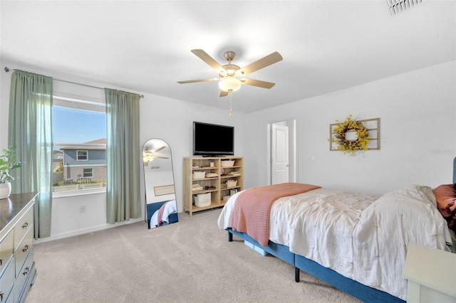bedroom with light carpet, visible vents, and ceiling fan