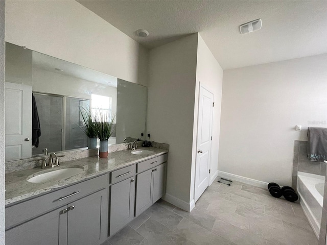 33034 Sand Creek Dr, Wesley Chapel, FL 33543 - bathroom with double vanity, a bath, a shower stall, and baseboards
