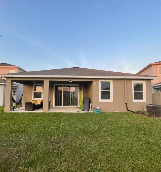 33034 Sand Creek Dr, Wesley Chapel, FL 33543 - back of house with central AC, a patio area, stucco siding, and a yard