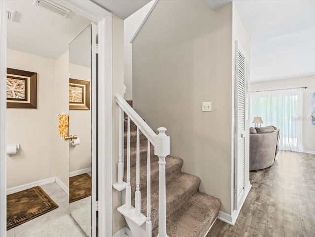 staircase with visible vents and baseboards