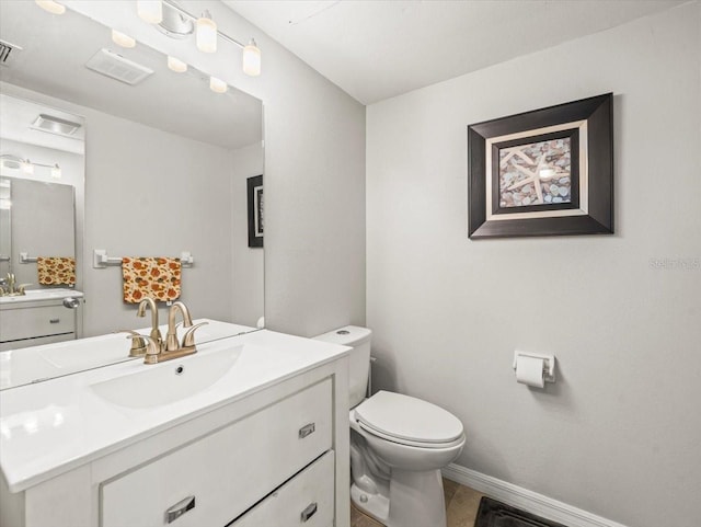 bathroom with toilet, two vanities, baseboards, and visible vents