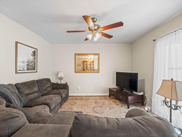 living area featuring baseboards and a ceiling fan