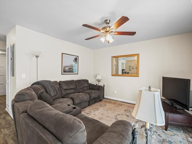 living room with baseboards, a ceiling fan, and wood finished floors