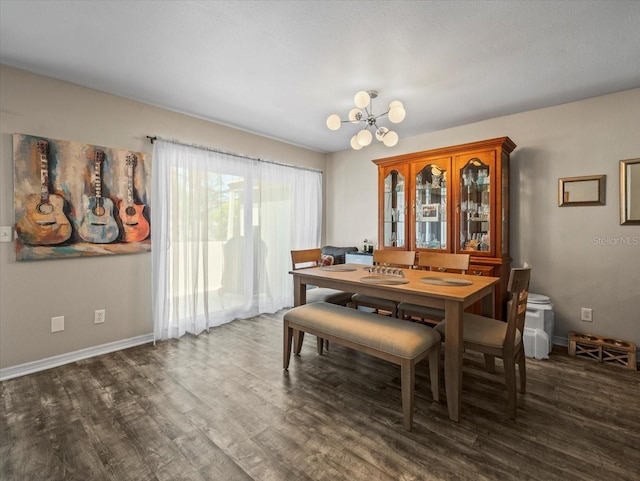 dining space featuring baseboards, an inviting chandelier, and wood finished floors
