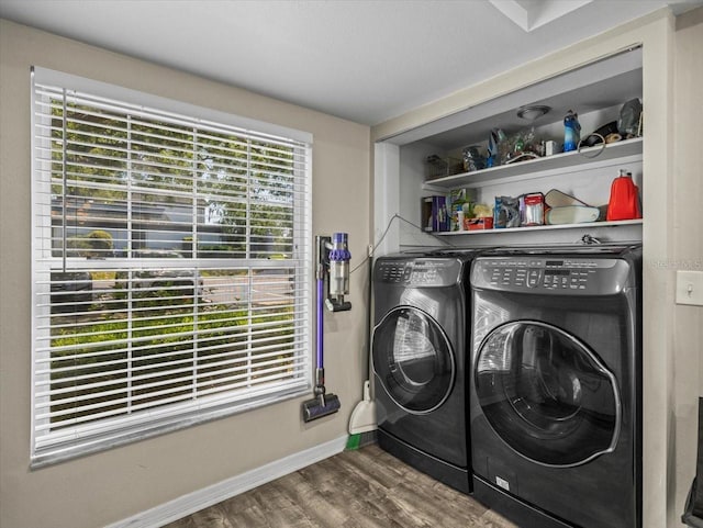 laundry area featuring washing machine and dryer, baseboards, laundry area, and wood finished floors