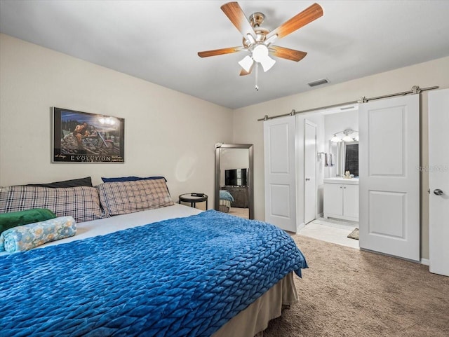 bedroom featuring carpet flooring, ceiling fan, visible vents, and connected bathroom