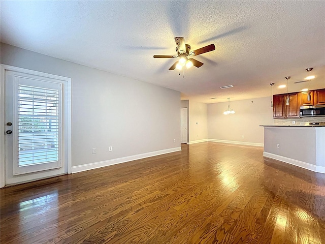 810 Island Walk Dr Unit 810, Tampa, FL 33602 - unfurnished living room with baseboards, dark wood-type flooring, a textured ceiling, and ceiling fan with notable chandelier
