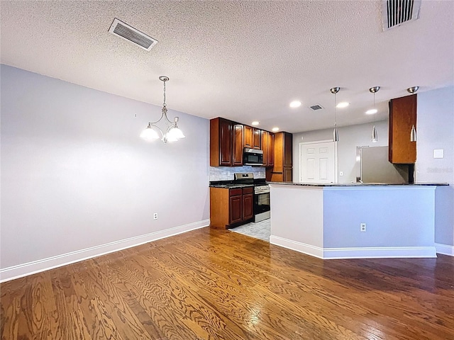 810 Island Walk Dr Unit 810, Tampa, FL 33602 - kitchen with stainless steel range oven, dark countertops, visible vents, and fridge