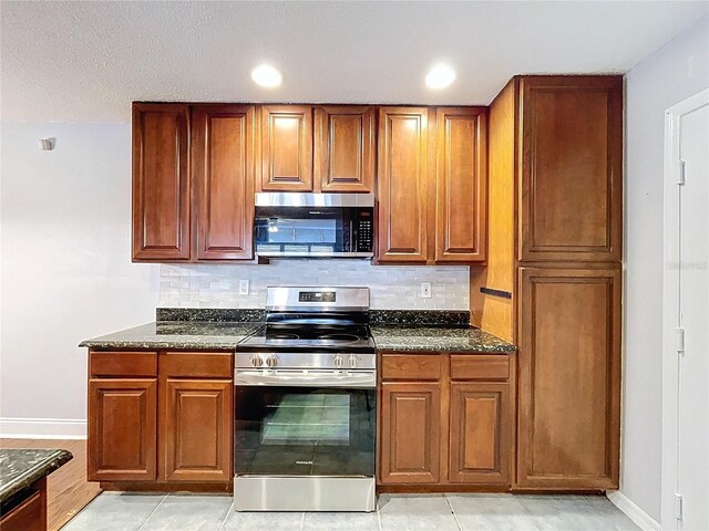 810 Island Walk Dr Unit 810, Tampa, FL 33602 - kitchen with backsplash, brown cabinets, appliances with stainless steel finishes, and baseboards