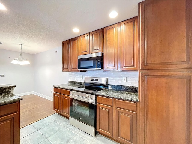 810 Island Walk Dr Unit 810, Tampa, FL 33602 - kitchen with brown cabinets, appliances with stainless steel finishes, baseboards, and decorative backsplash