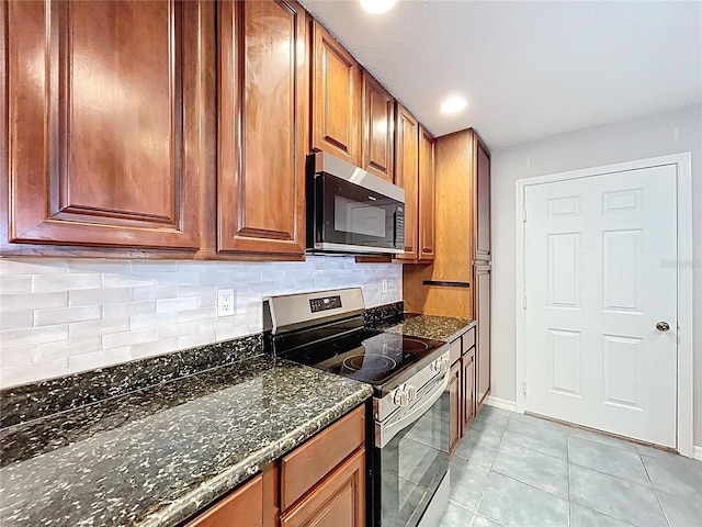 810 Island Walk Dr Unit 810, Tampa, FL 33602 - kitchen featuring dark stone counters, decorative backsplash, light tile patterned floors, baseboards, and appliances with stainless steel finishes