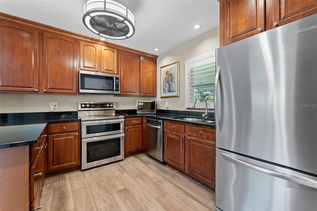 807 W Braddock St, Tampa, FL 33603 - kitchen featuring brown cabinetry, light wood-style flooring, recessed lighting, appliances with stainless steel finishes, and a sink