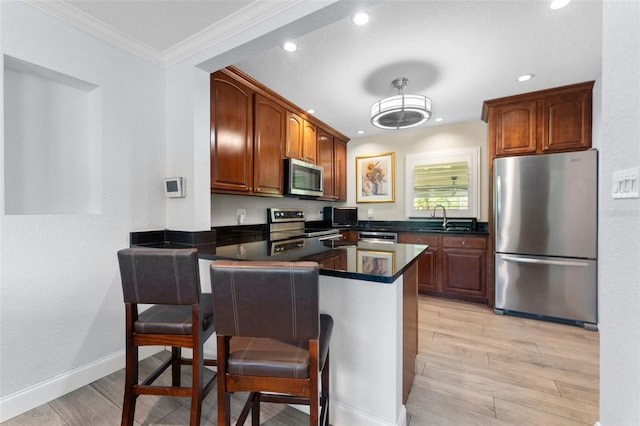 807 W Braddock St, Tampa, FL 33603 - kitchen with light wood-type flooring, a peninsula, dark countertops, stainless steel appliances, and a sink