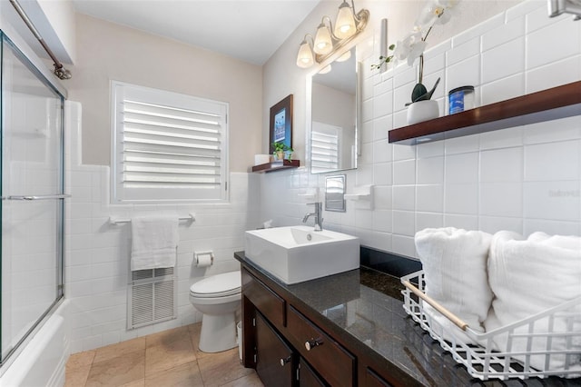 807 W Braddock St, Tampa, FL 33603 - bathroom featuring vanity, toilet, combined bath / shower with glass door, tile walls, and tile patterned floors
