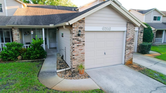 view of front of home with driveway, covered porch, a garage, brick siding, and a shingled roof