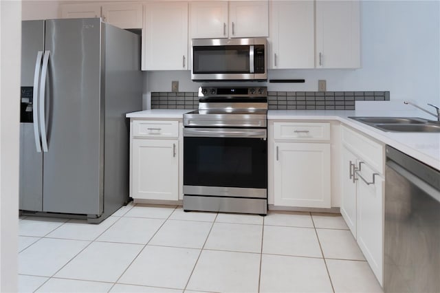kitchen with white cabinets, appliances with stainless steel finishes, a sink, and light countertops