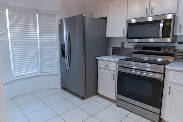 kitchen featuring white cabinets, light countertops, light tile patterned floors, and appliances with stainless steel finishes