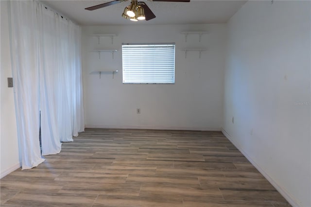 spare room with wood finished floors, baseboards, and ceiling fan