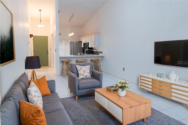 living area with high vaulted ceiling and light tile patterned floors