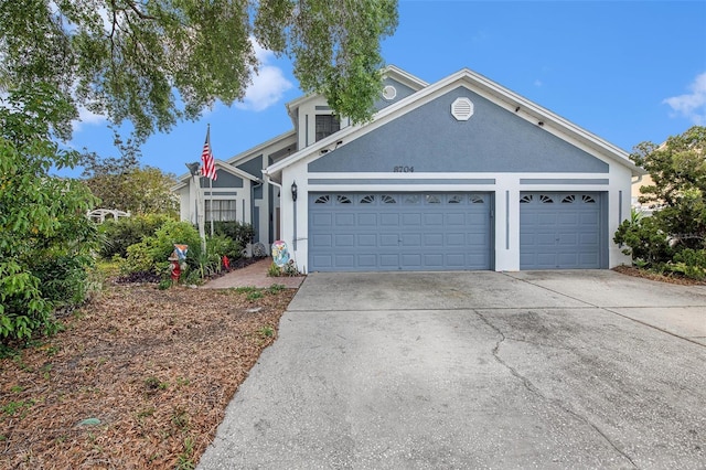 8704 Tarrington Pl, Tampa, FL 33635 - view of front of home with stucco siding, driveway, and a garage