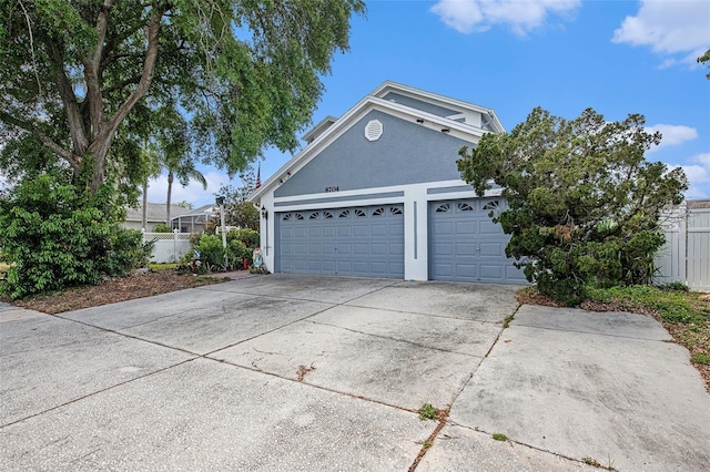 8704 Tarrington Pl, Tampa, FL 33635 - view of front of house with driveway, stucco siding, and a garage