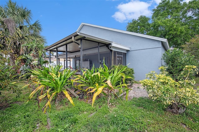 8704 Tarrington Pl, Tampa, FL 33635 - view of side of property with a sunroom and stucco siding