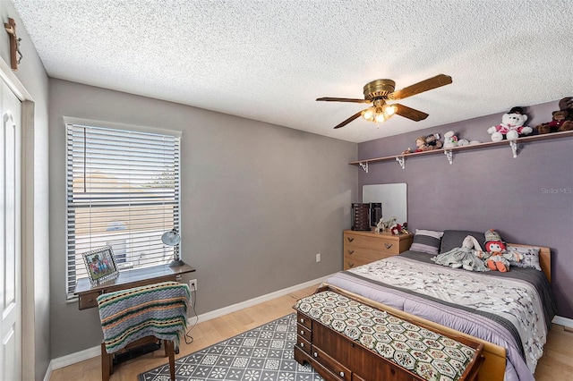 8704 Tarrington Pl, Tampa, FL 33635 - bedroom with multiple windows, light wood finished floors, a textured ceiling, ceiling fan, and baseboards