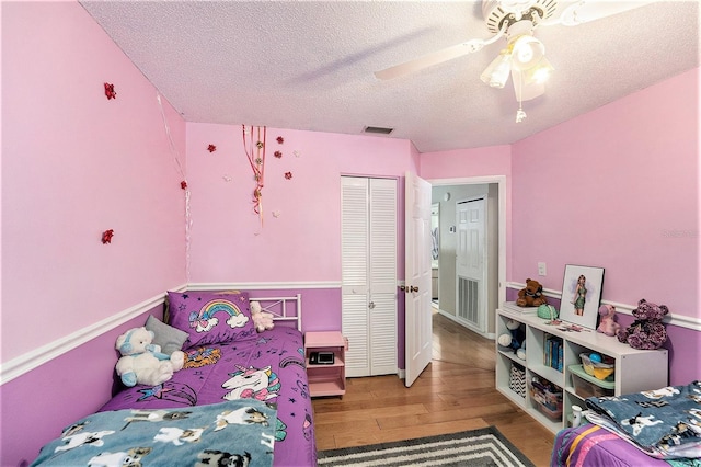 8704 Tarrington Pl, Tampa, FL 33635 - bedroom with wood finished floors, a textured ceiling, a closet, and a ceiling fan