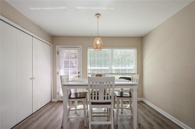 dining space featuring wood finished floors and baseboards