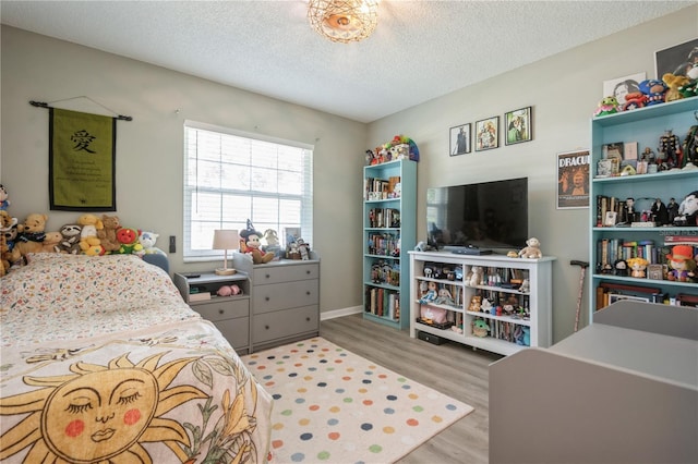 bedroom with wood finished floors and a textured ceiling