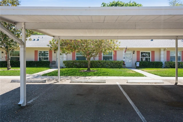 view of front of property featuring a front lawn and covered parking