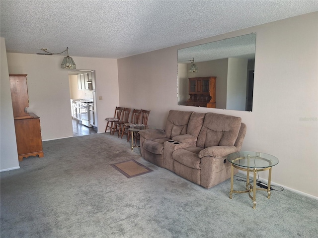 living area featuring carpet and a textured ceiling