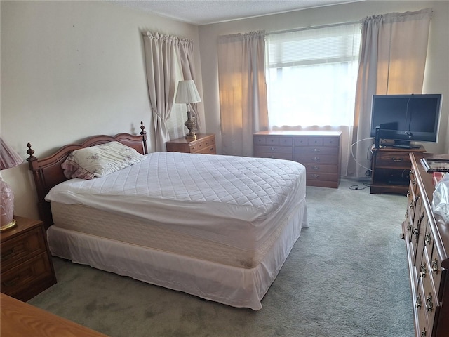 bedroom with light colored carpet and a textured ceiling