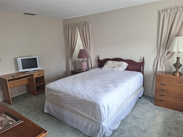 bedroom with a textured ceiling, visible vents, and carpet