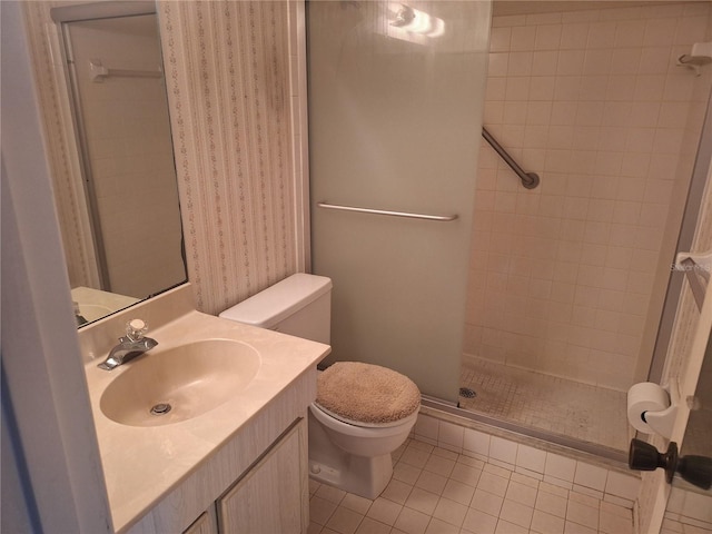 bathroom with toilet, a tile shower, tile patterned flooring, and vanity