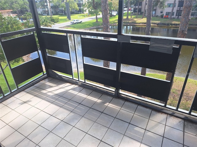 unfurnished sunroom featuring a water view